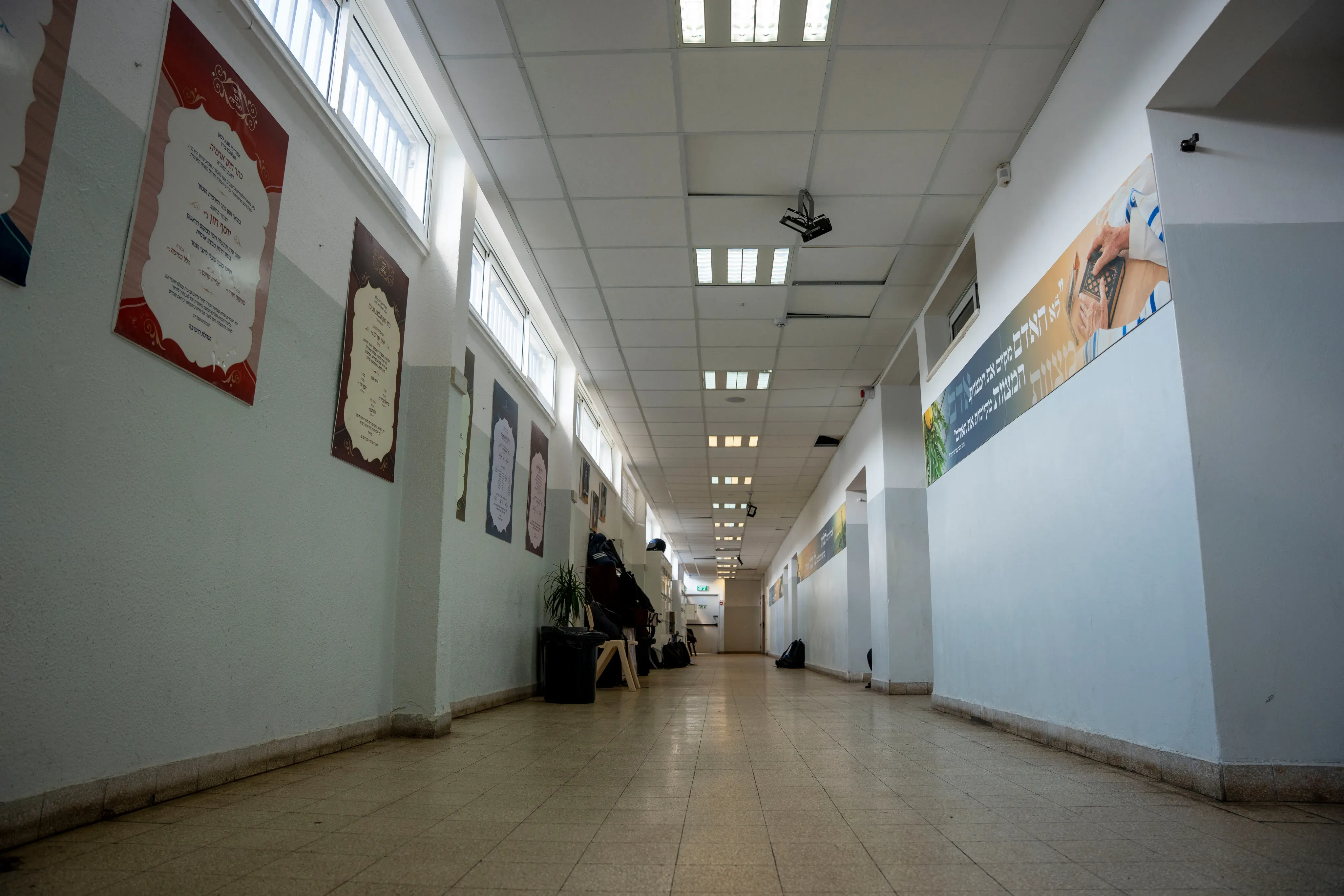 מסדרון ארוך בבית הספר עם מודעות ולוחות מידע צבעוניים על הקירות