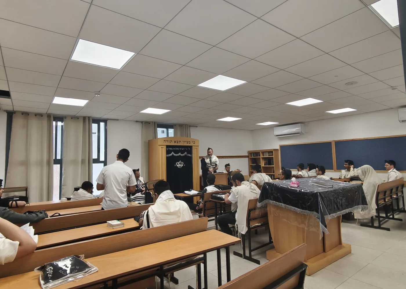 בית המדרש של הישיבה בחריש, תלמידים לומדים ליד שולחנות מול ארון הקודש