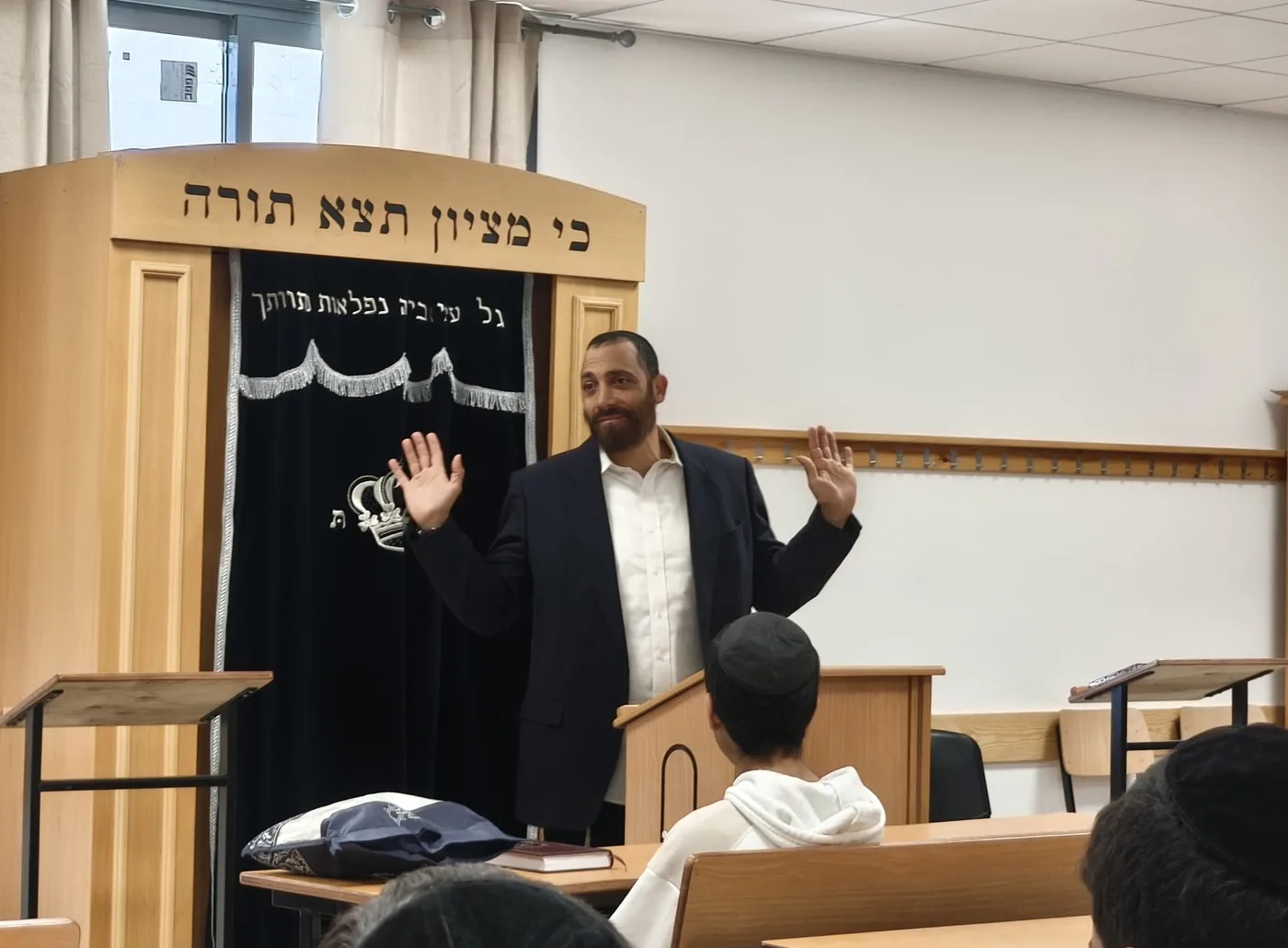 רב מוסר שיעור לתלמידים מול ארון הקודש בבית המדרש