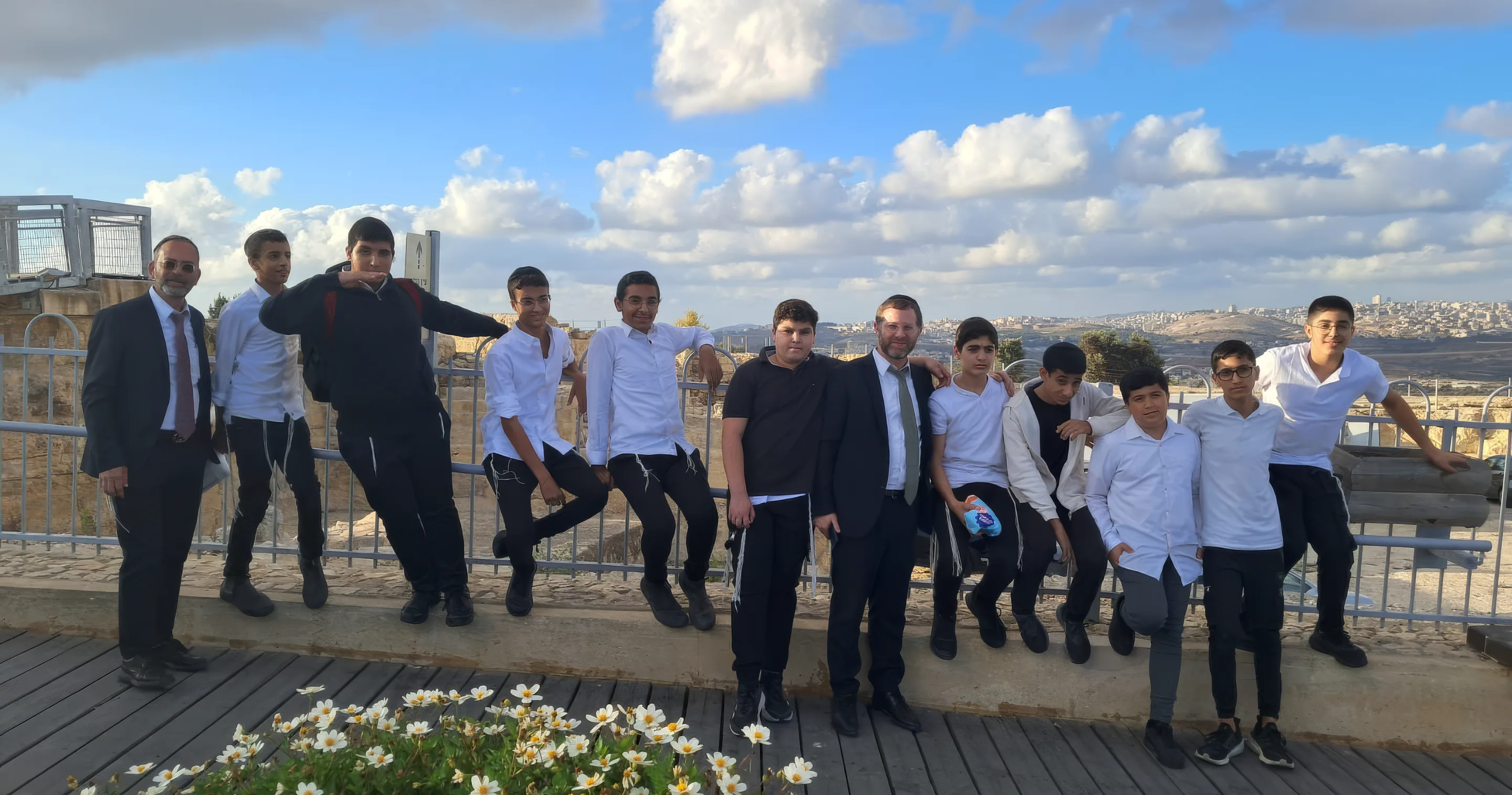 קבוצת תלמידים ורבנים מצטלמים על מרפסת תצפית מול נוף