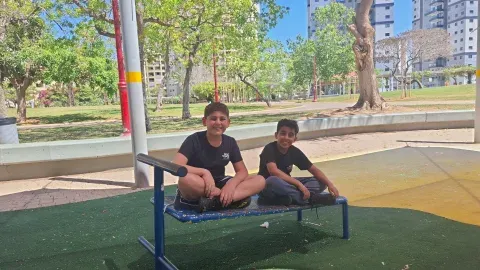 שני תלמידים יושבים על ספסל בחצר