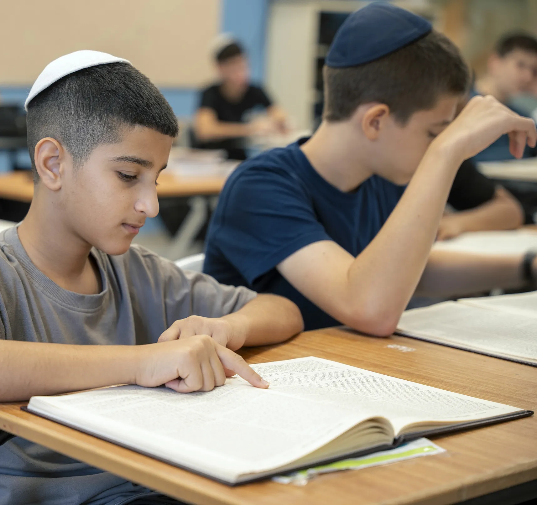 שני תלמידים לומדים גמרא בחברותא, אחד מצביע על שורה בדף
