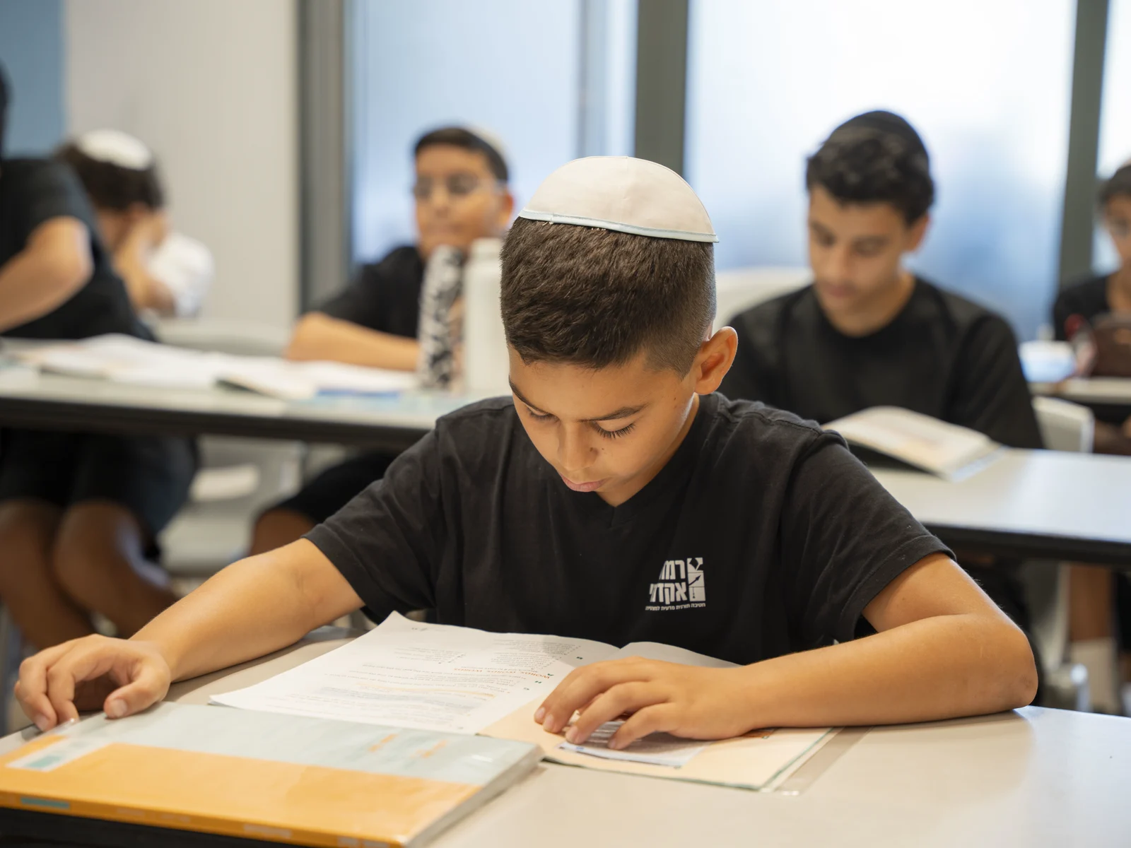 תלמיד מרוכז בחוברת העבודה בכיתה