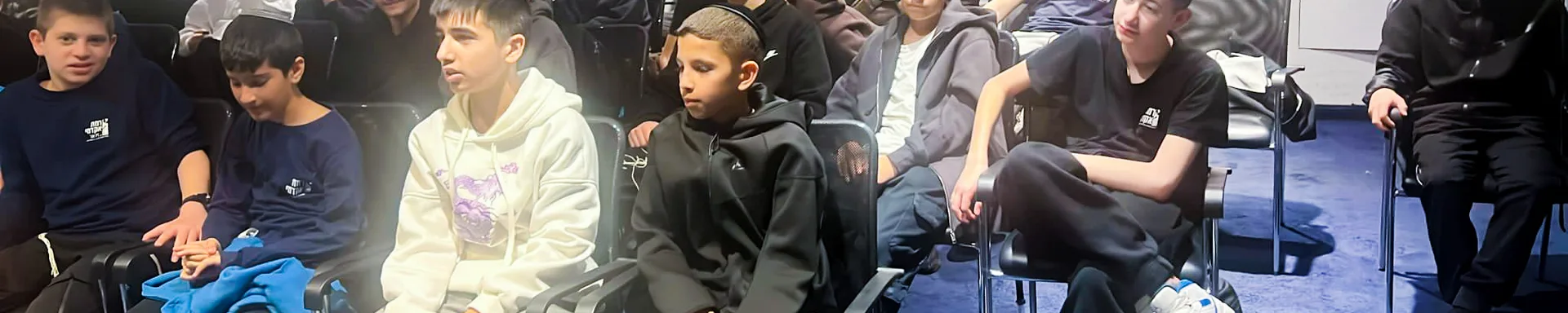 תלמידים יושבים באולם משכן התכלת
