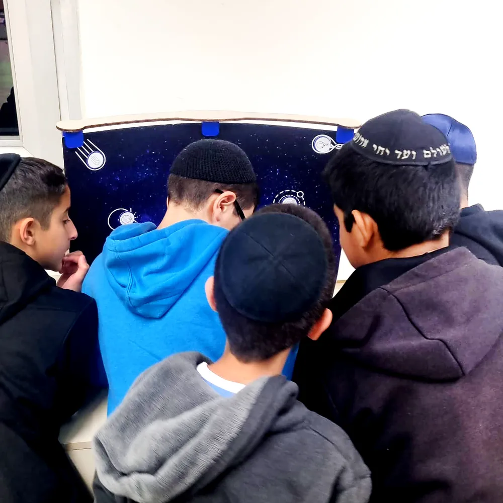 תלמידים סביב תיבת פעילות מעוצבת כחלל - יום של ניסויים במכון דוידסון