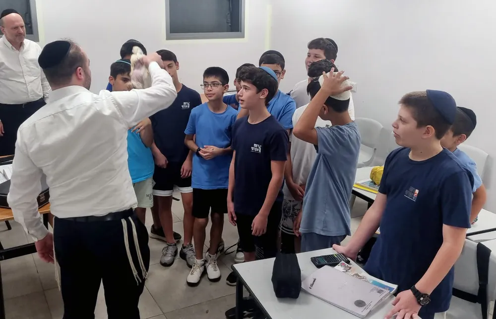 מבוגר מדגים חפץ בפני תלמידים בכיתה - רמת אקדמי באר יעקב, ימי תשרי בבית הספר