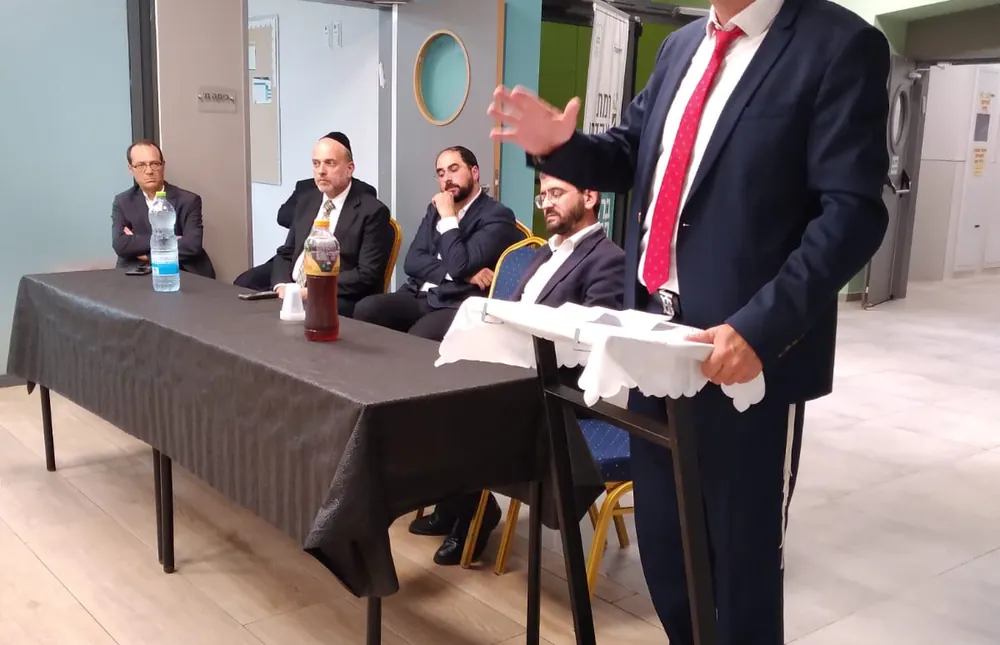 גבר בחליפה מדבר ליד שולחן פאנל - רמת אקדמי באר יעקב, מפגש הורים ותלמידים