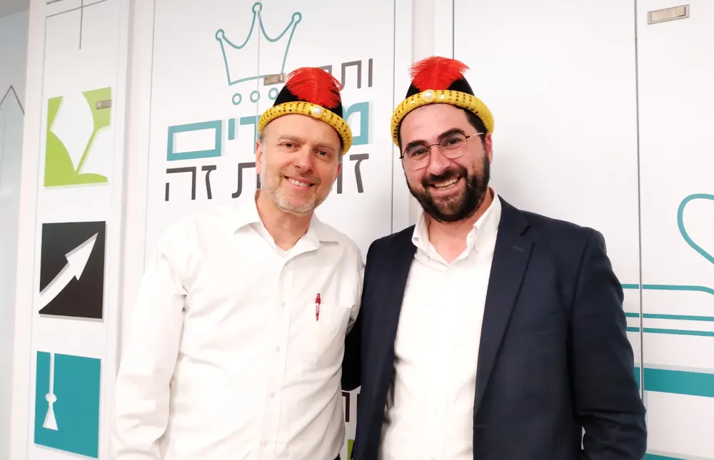 שני מבוגרים מחייכים עם כובעי פורים - רמת אקדמי באר יעקב, אדר נכנס בריקוד