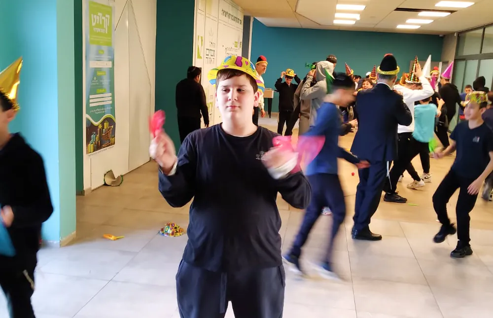 תלמיד עם שני רעשנים בחגיגת פורים - רמת אקדמי באר יעקב, אדר נכנס בריקוד