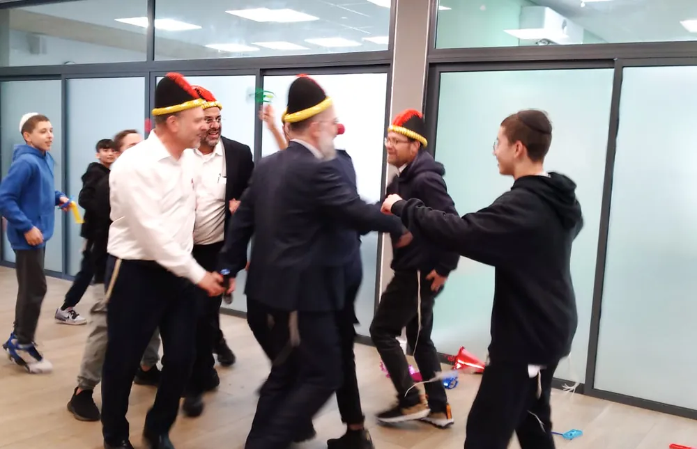 תלמידים ומבוגרים רוקדים ליד קיר זכוכית - רמת אקדמי באר יעקב, אדר נכנס בריקוד