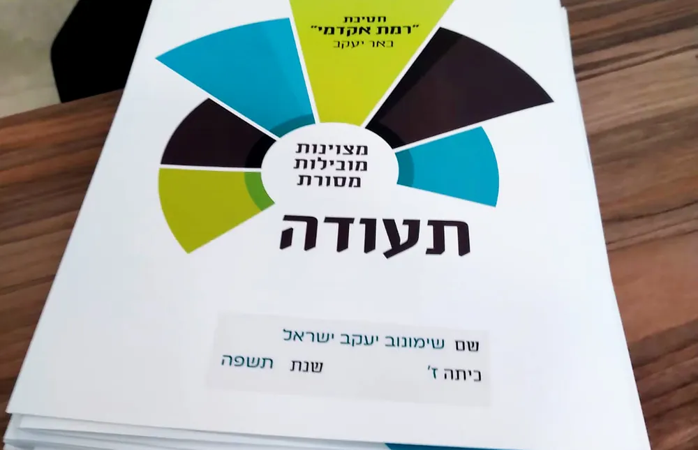 ערמת תעודות על שולחן עץ - רמת אקדמי באר יעקב, מחזיקים את ההצלחה