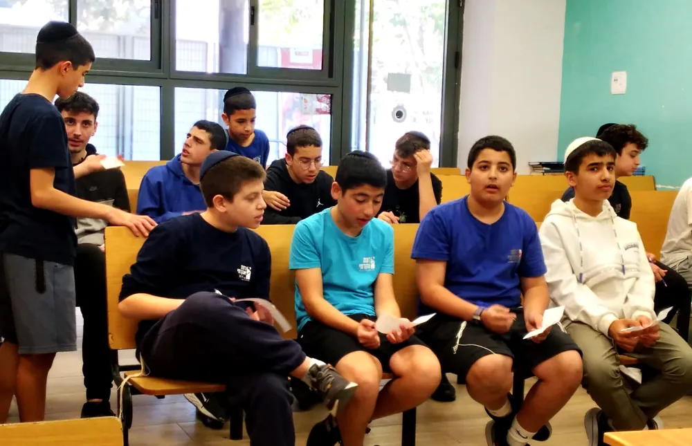 תלמידים יושבים עם דפי פעילות בידיהם - רמת אקדמי באר יעקב, מתמודדים באנגלית