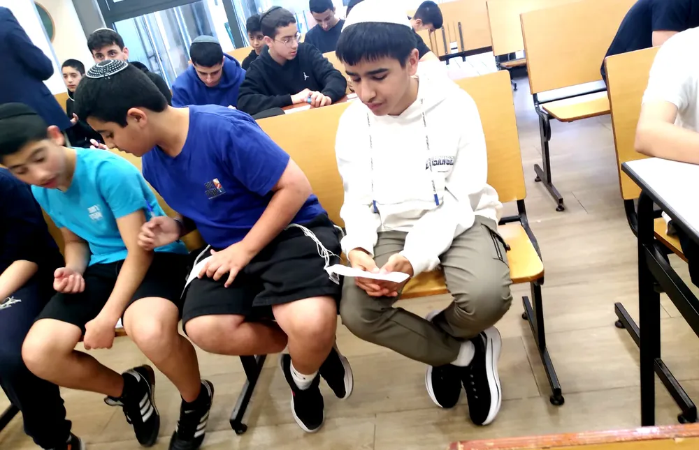 תלמידים מעיינים בדפי פעילות בכיתה - רמת אקדמי באר יעקב, מתמודדים באנגלית