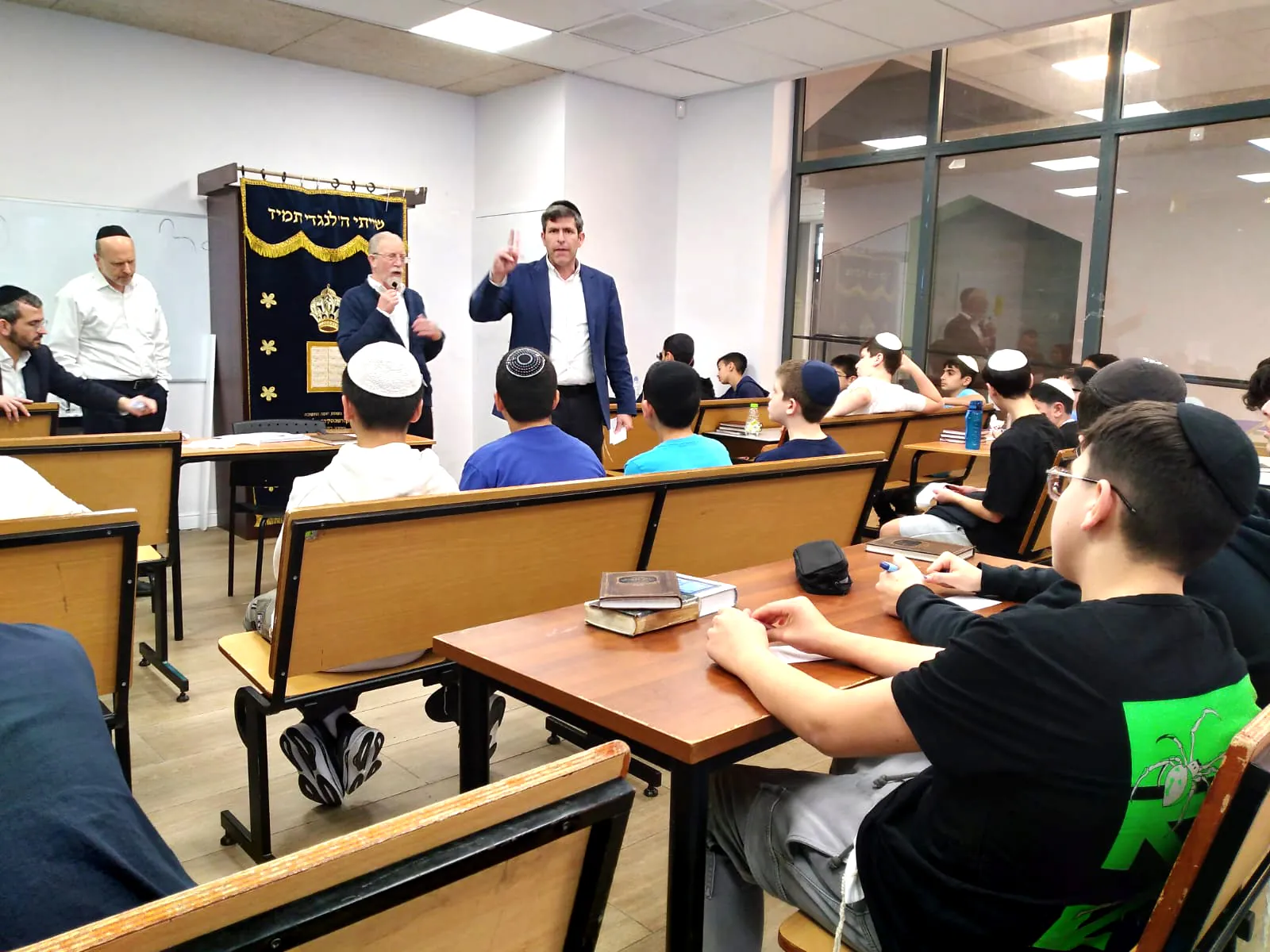 מבוגר מדבר במיקרופון מול תלמידים ביום אנגלית - יום אנגלית ברמת אקדמי