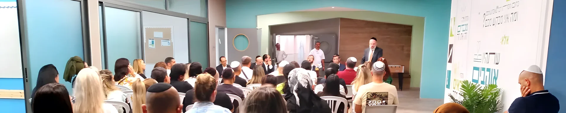 הורים ותלמידים יושבים באולם במפגש המשותף