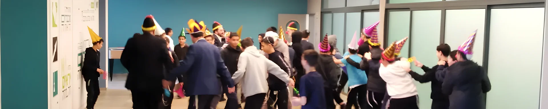 תלמידים רוקדים עם כובעי מסיבה לכבוד ראש חודש אדר