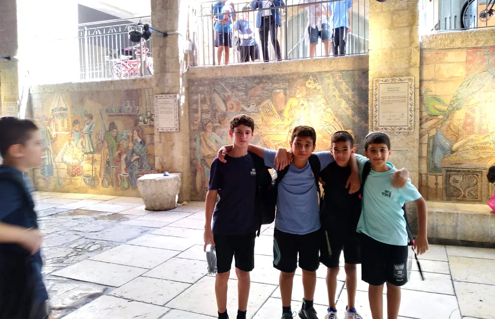 ארבעה תלמידים מצטלמים ליד פסיפסים בירושלים - יוצאים יחד: ירושלים והפארק