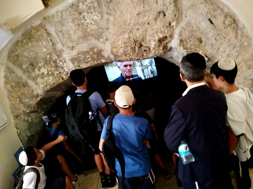 תלמידים ומבוגר צופים במסך בכניסה לחלל אבן - יוצאים יחד: ירושלים והפארק