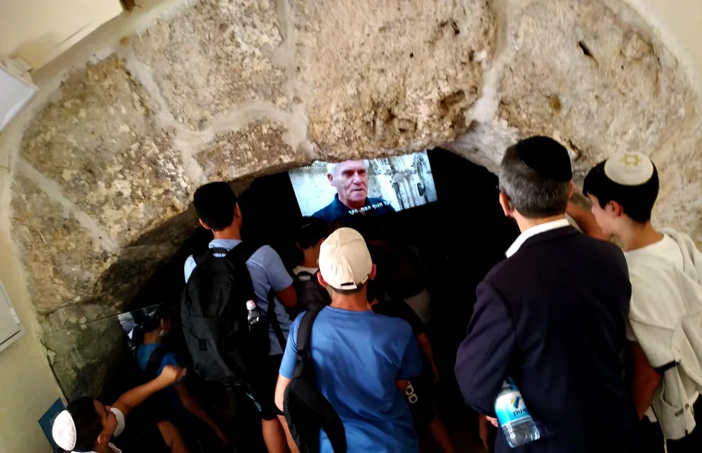 תלמידים ומבוגר צופים במסך בכניסה לחלל אבן - יוצאים יחד: ירושלים והפארק