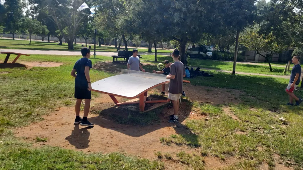 תלמידים משחקים בכדור סביב שולחן בפארק - יוצאים יחד: ירושלים והפארק
