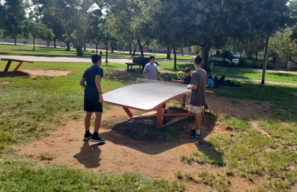 תלמידים משחקים בכדור סביב שולחן בפארק - יוצאים יחד: ירושלים והפארק