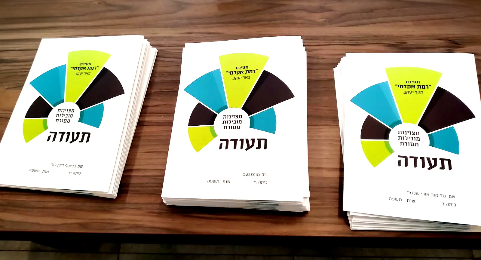 שלוש ערמות של תעודות על שולחן - יום חלוקת התעודות