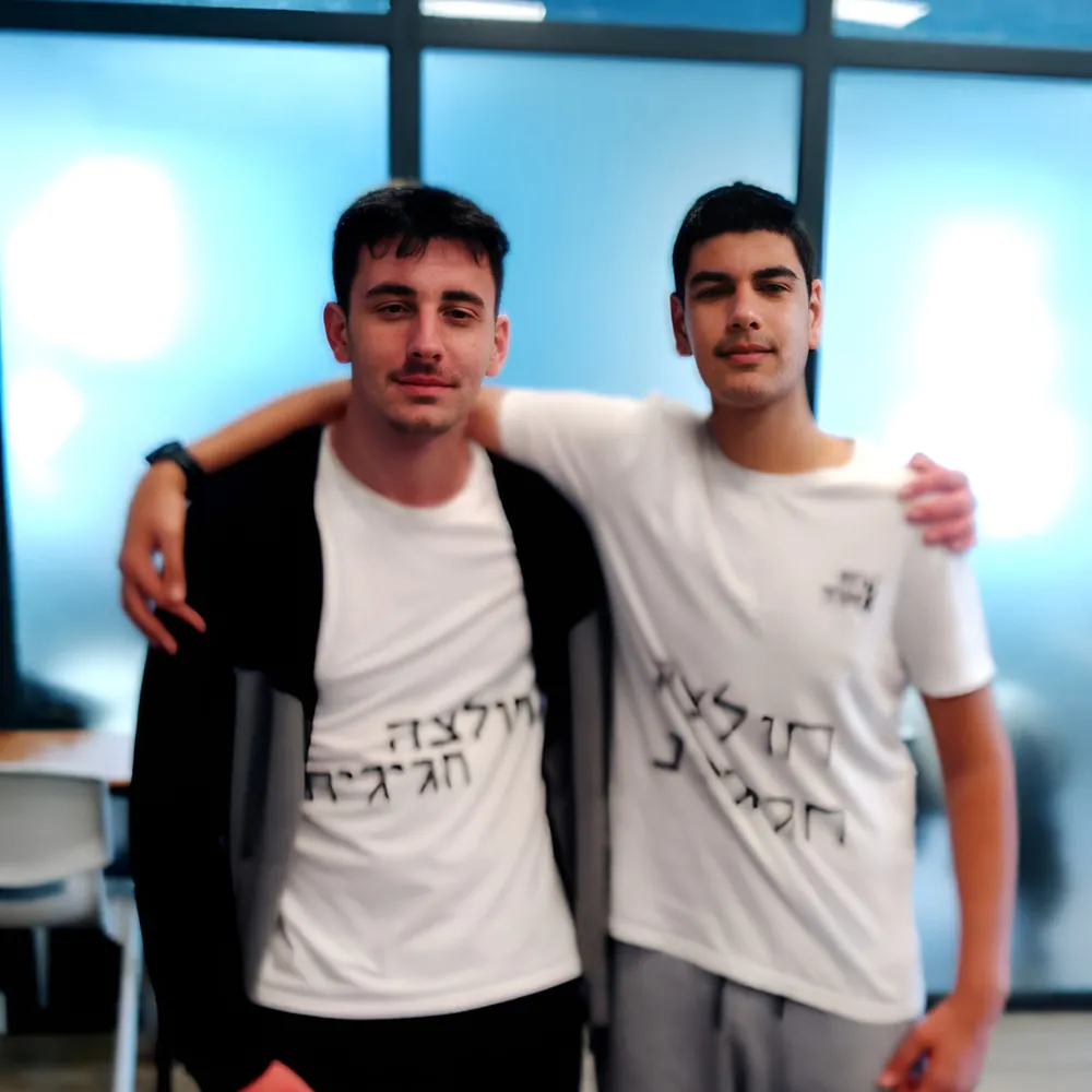 שני תלמידים עומדים מחובקים מול המצלמה - יום חלוקת התעודות