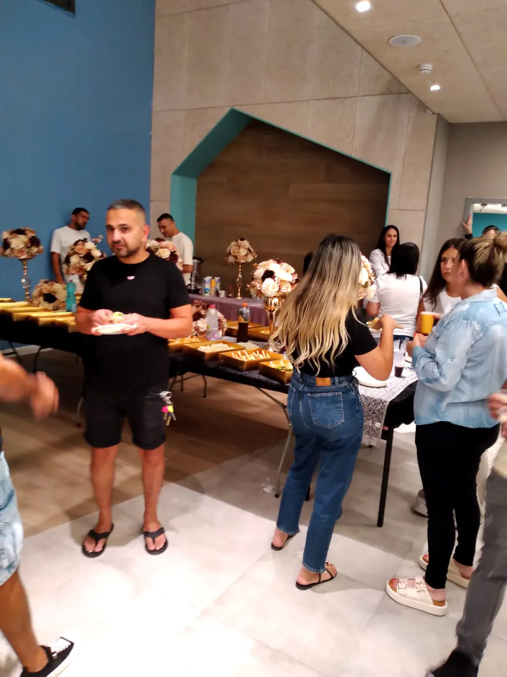אורחים ליד שולחן כיבוד באולם - תלמידים והורים נפגשו ברמת אקדמי