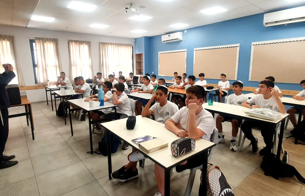 דובר עומד מול תלמידים יושבים בכיתה - תלמידים והורים נפגשו ברמת אקדמי