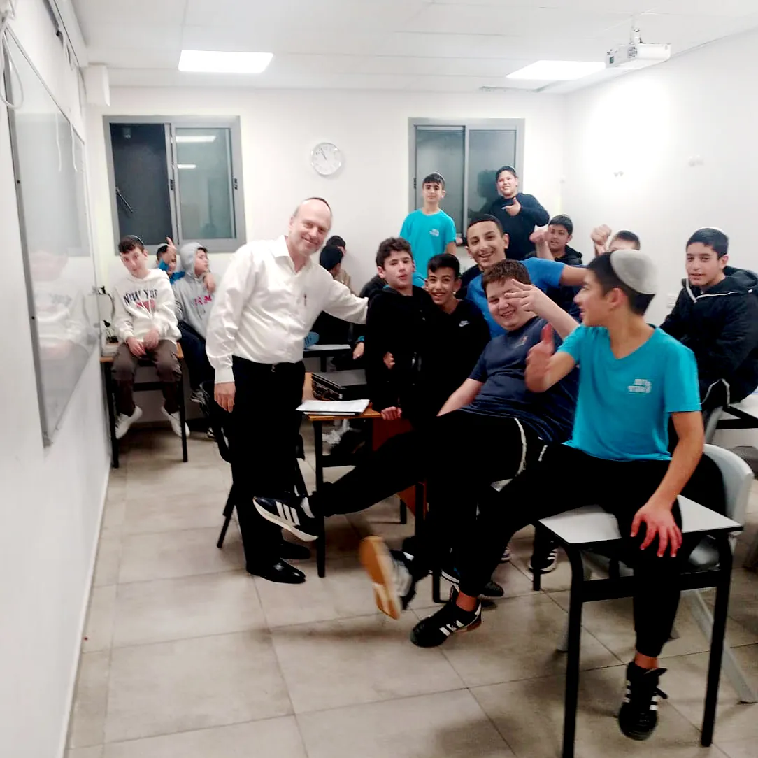 איש צוות ותלמידים מחייכים בכיתה - שומרים על שגרה, יחד