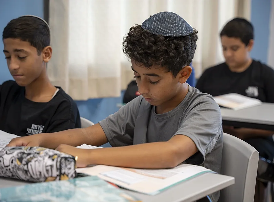 שלושה תלמידים לומדים זה לצד זה בכיתה
