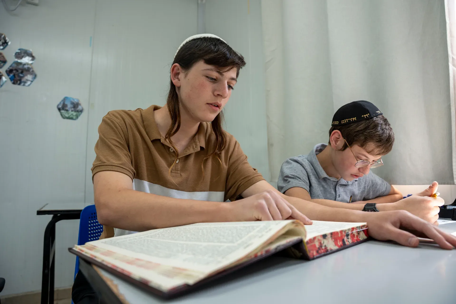 שני תלמידים לומדים יחד בחברותא סביב שולחן