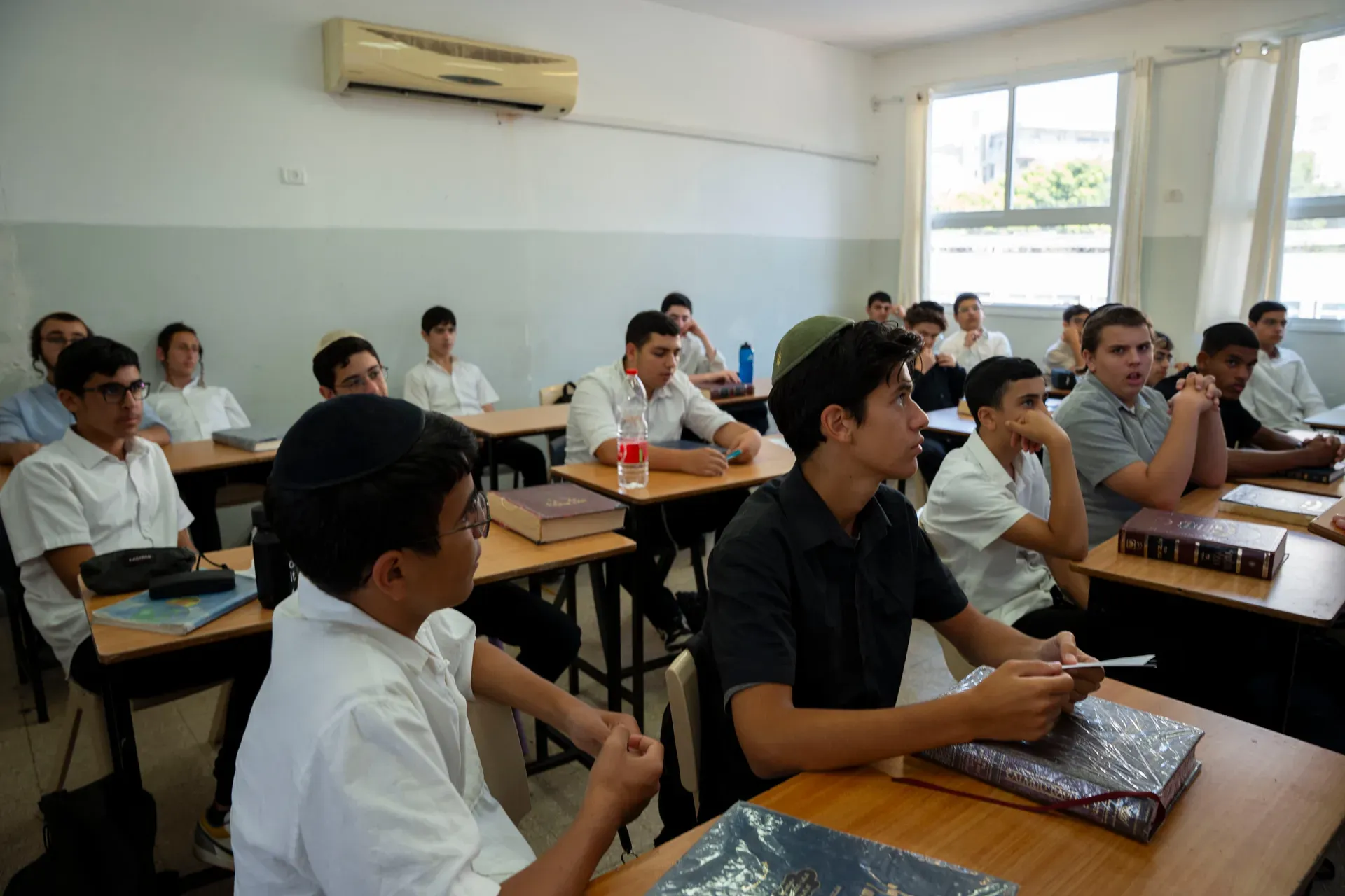 כיתה מלאה בתלמידים יושבים ליד השולחנות