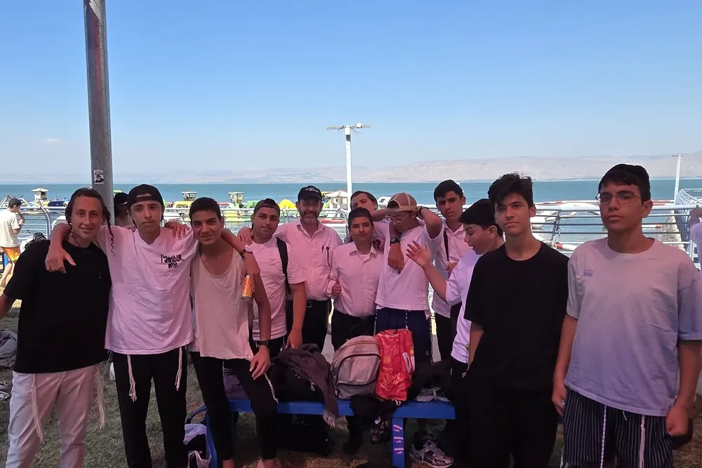 קבוצת תלמידים עם הרב ליד מדשאת החוף - יום על המים
