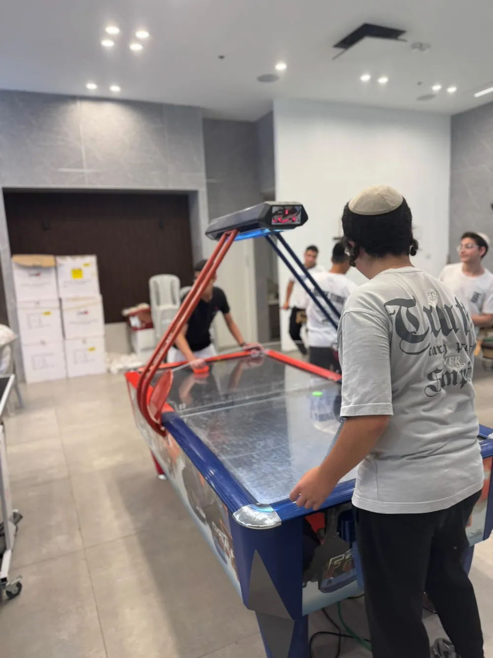 בחור ליד שולחן הוקי אוויר בחדר המשחקים - ישיבת בין הזמנים