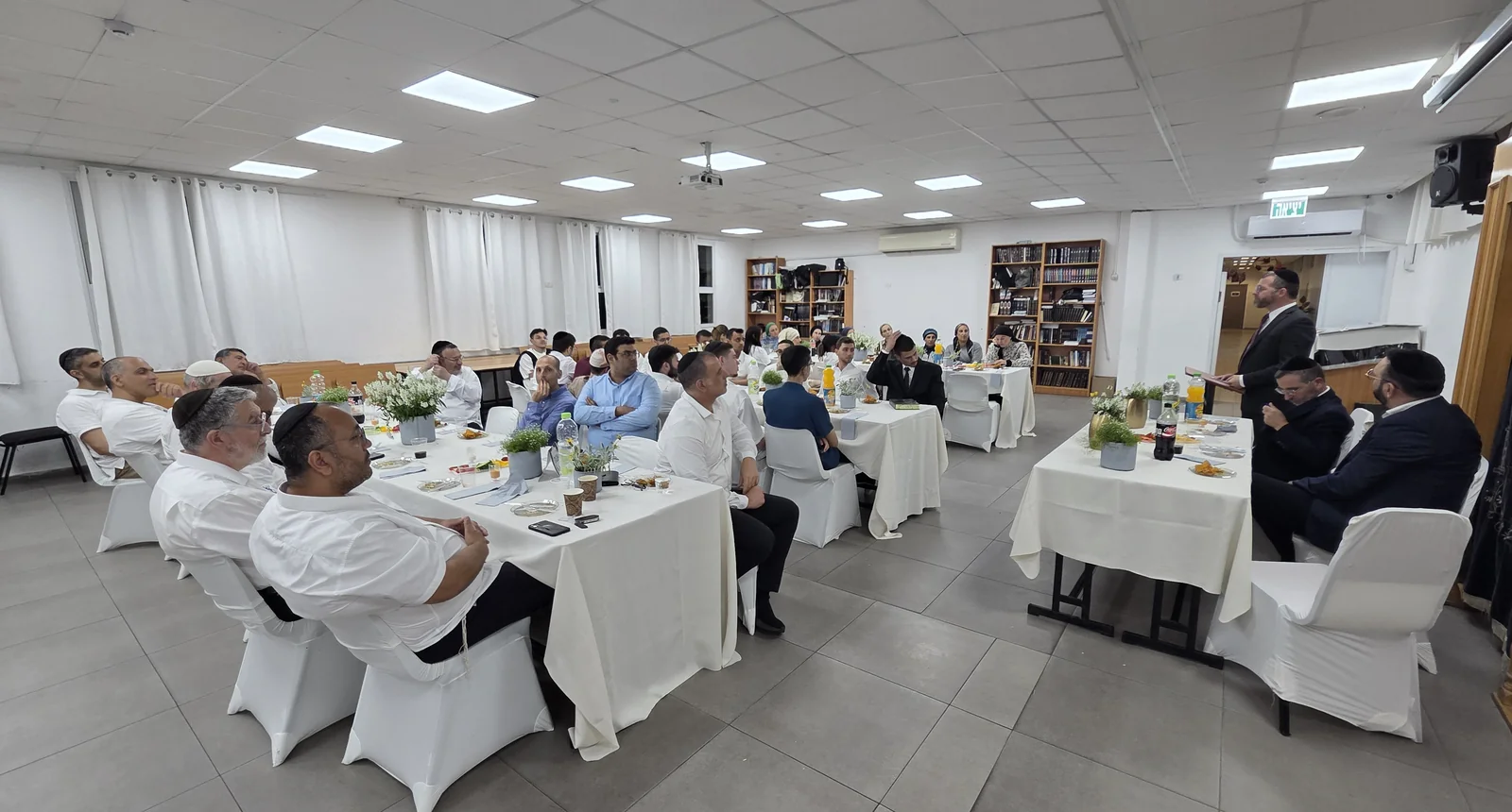 אולם הסעודה והדובר ליד הדוכן - מסיבת סיום לשיעור ד׳