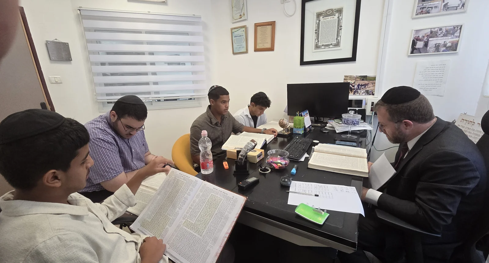 מבט על תלמידים ורב הלומדים סביב שולחן - מבחן אצל ראש הישיבה