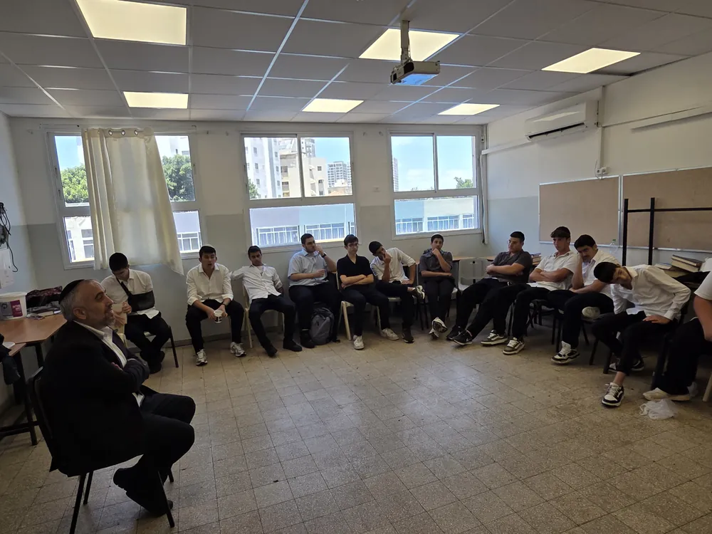 דובר מבוגר פונה לקבוצת תלמידים בכיתה - יום עיון בח׳ בתמוז