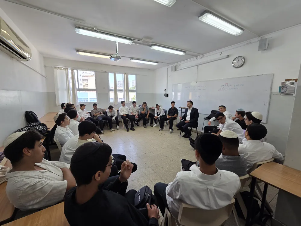 מעגל שיחה כיתתי עם תלמידים ודובר בחליפה - יום עיון בח׳ בתמוז