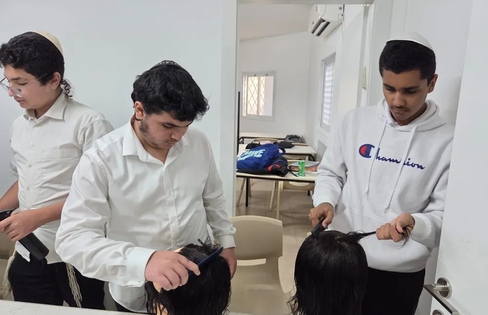 שלושה תלמידים מסרקים ראשי תרגול ליד דלת הכיתה - מגמת ספָּרוּת יוצאת לדרך