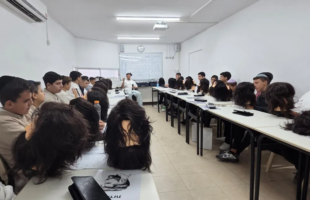 תלמידים סביב שולחנות ועליהם ראשי תרגול עם פאות - מגמת ספָּרוּת יוצאת לדרך