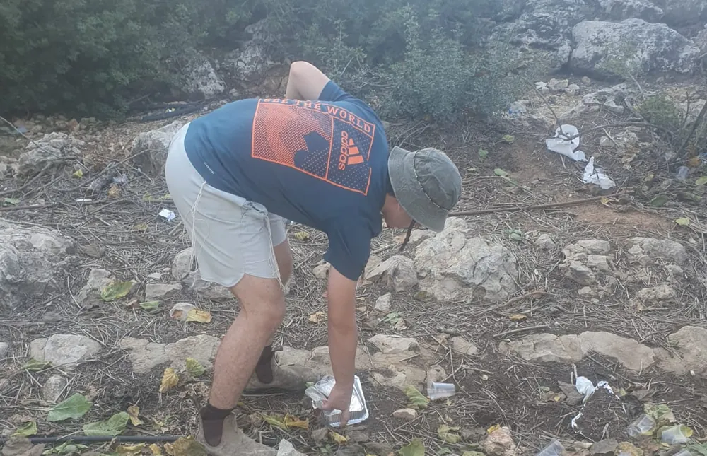 תלמיד אוסף פסולת מהשטח - יום על האופניים