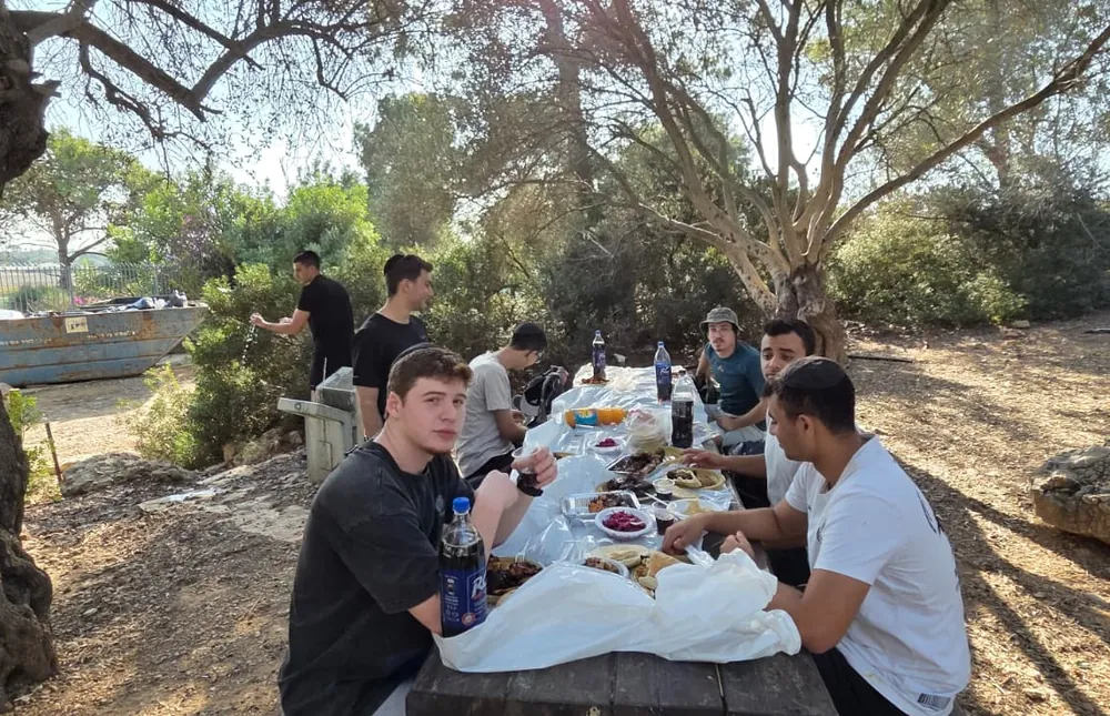 תלמידים בארוחה ליד עץ זית - יום על האופניים