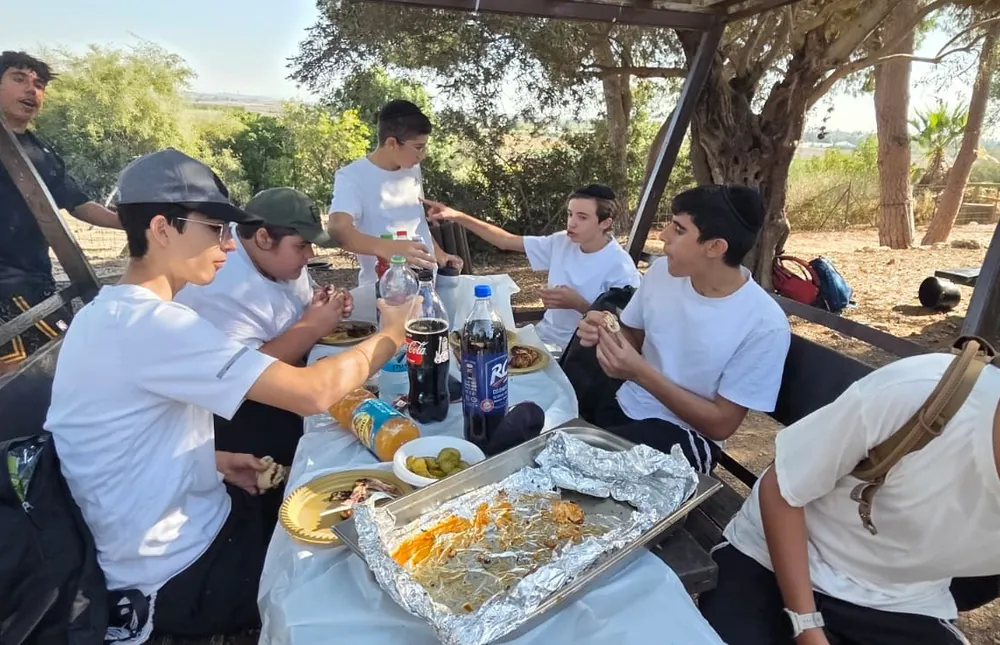 תלמידים בארוחת שטח תחת פרגולה - יום על האופניים