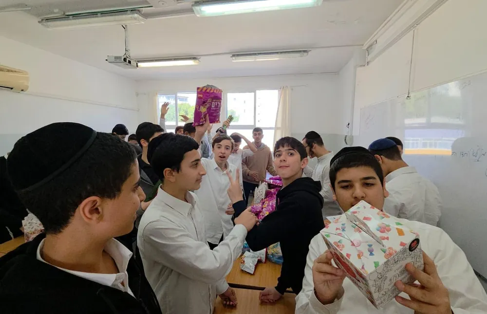 תלמידים מציגים חטיפים למארזים - חסד בקופסאות