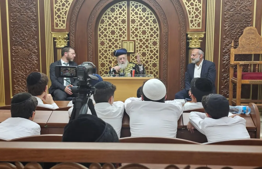 הרב נואם מול תלמידים ומצלמה על חצובה - המסע של אלול