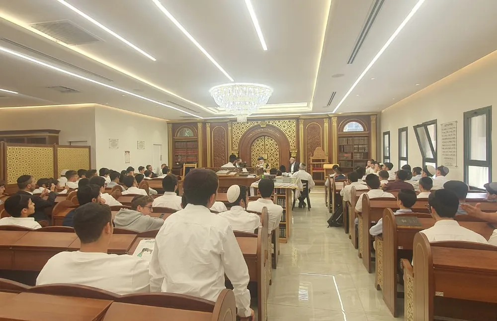 תלמידים מול ארון קודש מתחת לנברשת - המסע של אלול