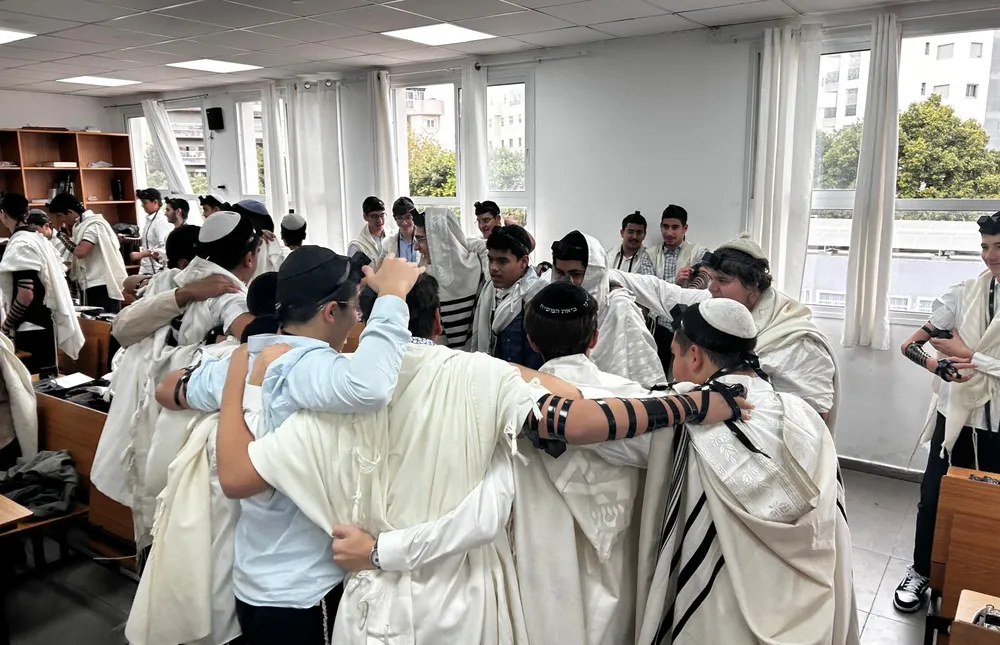 תלמידים בטליתות רוקדים יחד בבית המדרש - משנכנס אדר