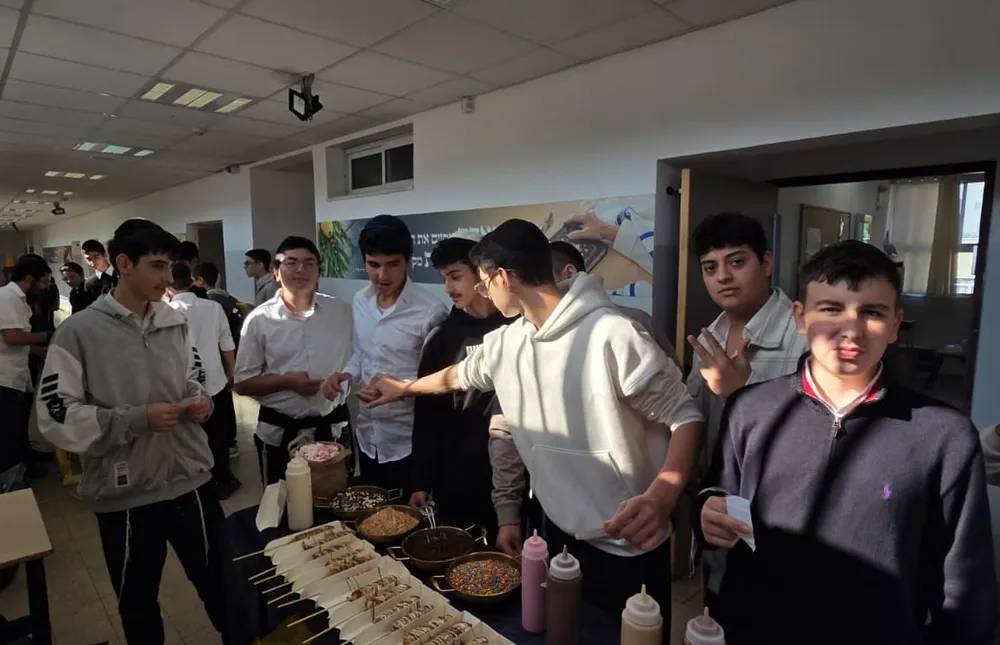 תלמידים מסביב לשולחן קינוחים ותוספות - מבחן של חורף