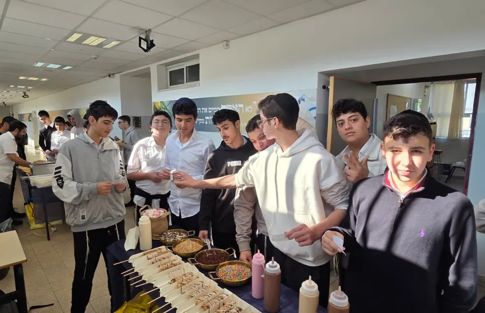 תלמידים סביב דוכן צ'ורוס עם רטבים ותוספות - מבחן של חורף